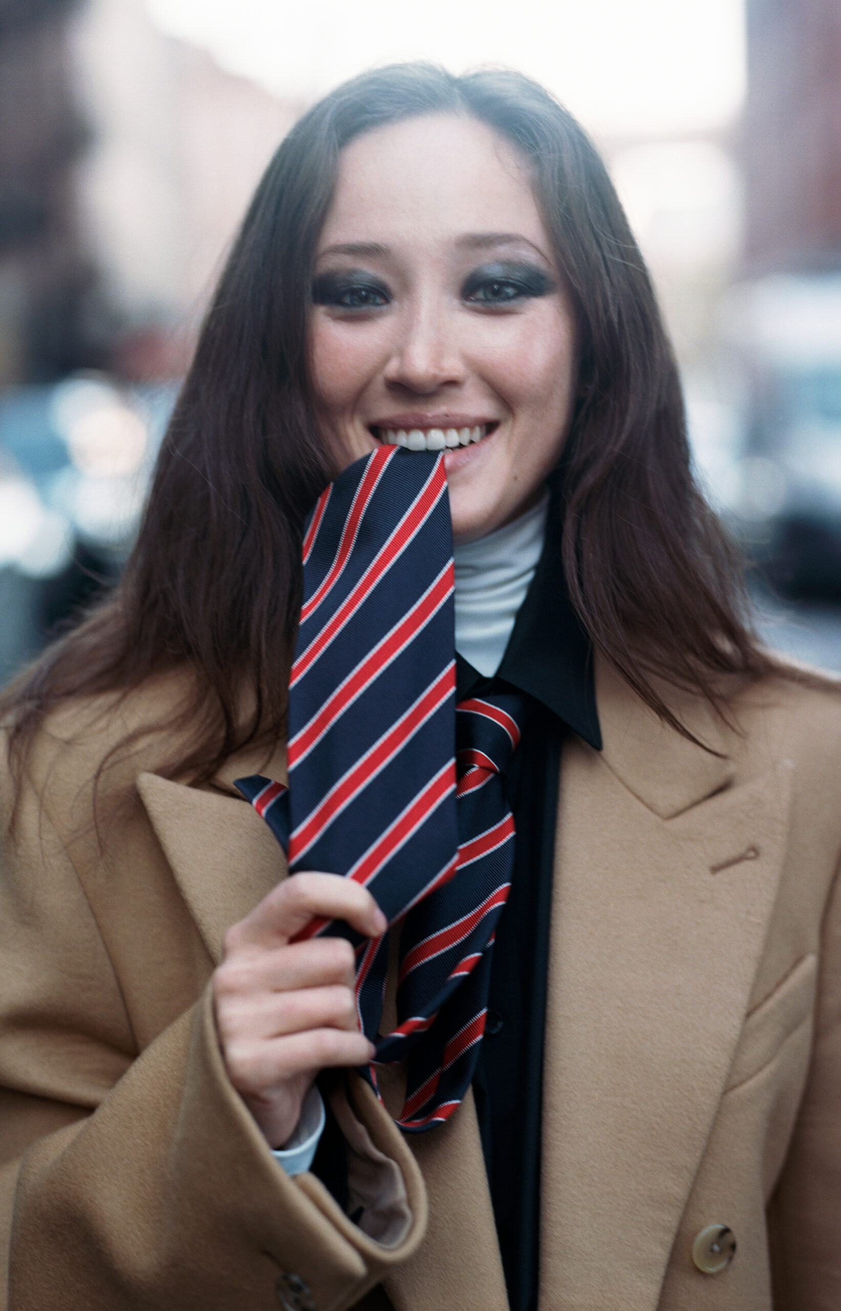 Havana Rose Liu biting a tie.