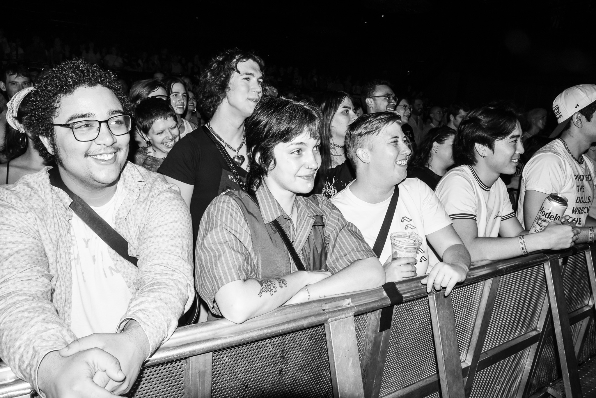 A crowd watches the Twinks vs Dolls match with smiles on their faces.