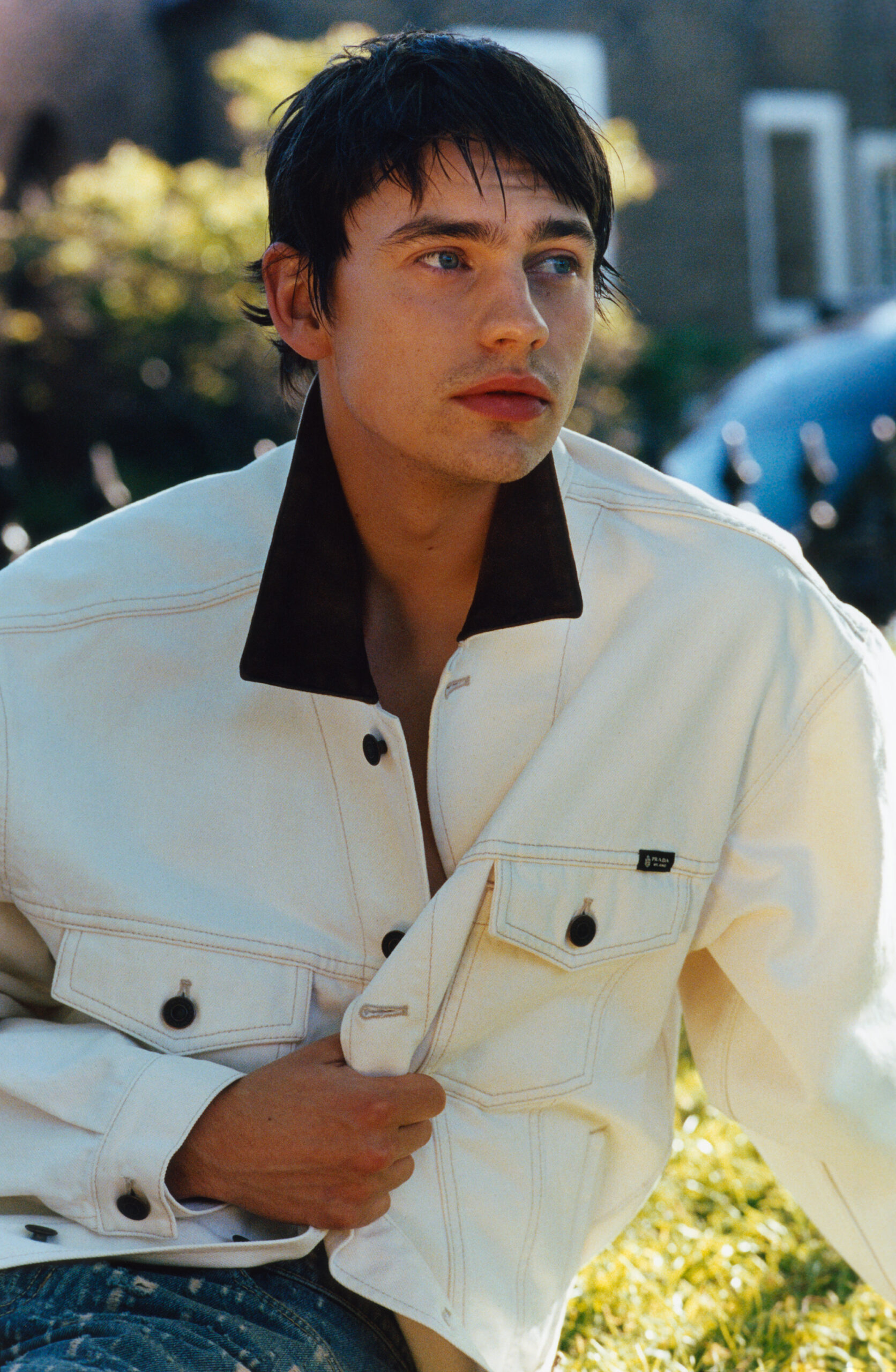 Spike Fearn looks to the right and clutches a white denim jacket