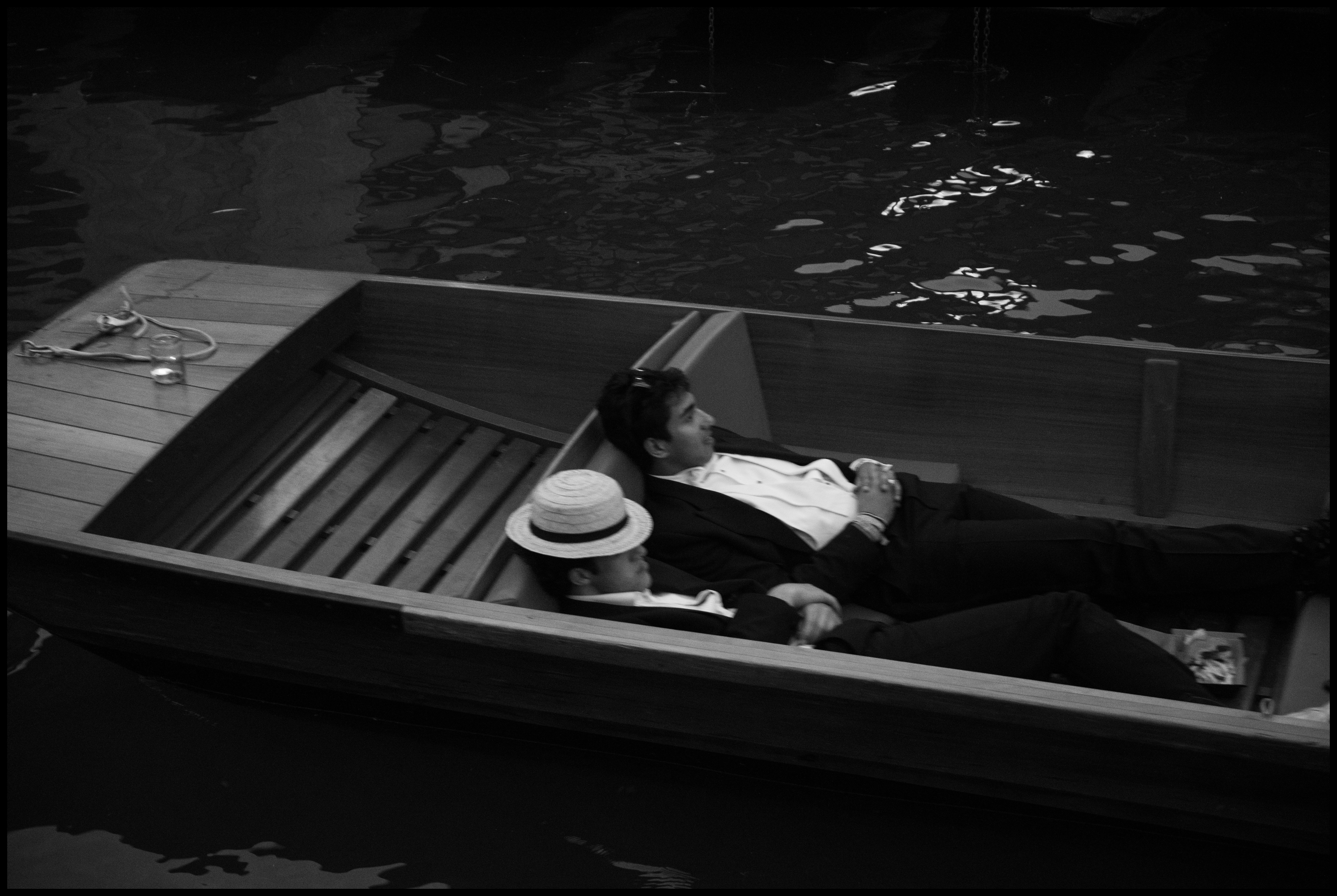 Students in black tie sleep in a rowing boat at Cambridge May Ball