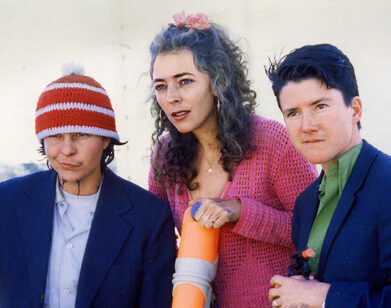 Harry Dodge, Stanya Kahn, and Silas Howard standing together and looking out in the distance in a film still from By Hook or By Crook