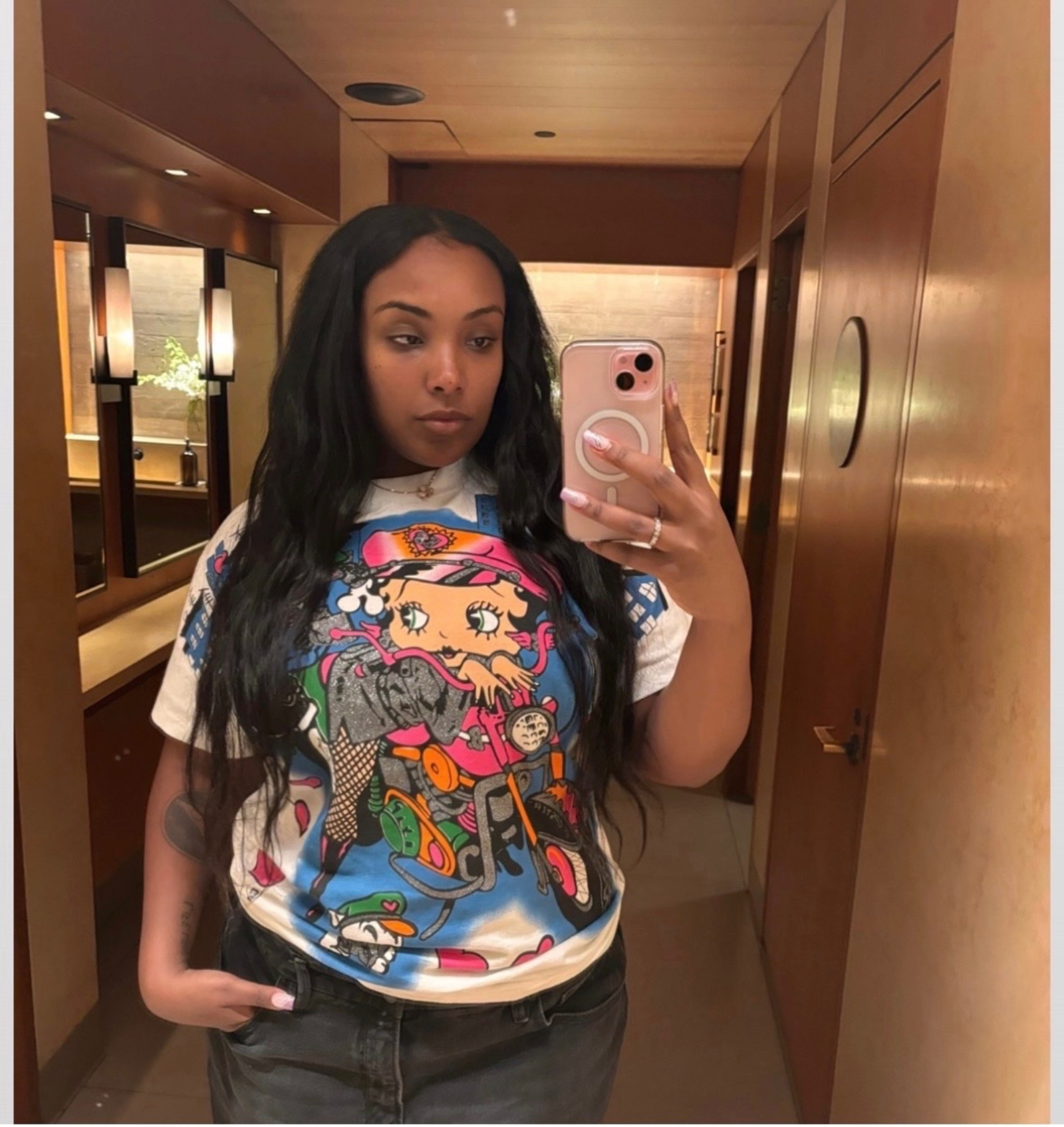 Aida Osman taking a selfie wearing a Bettie Boop t-shirt