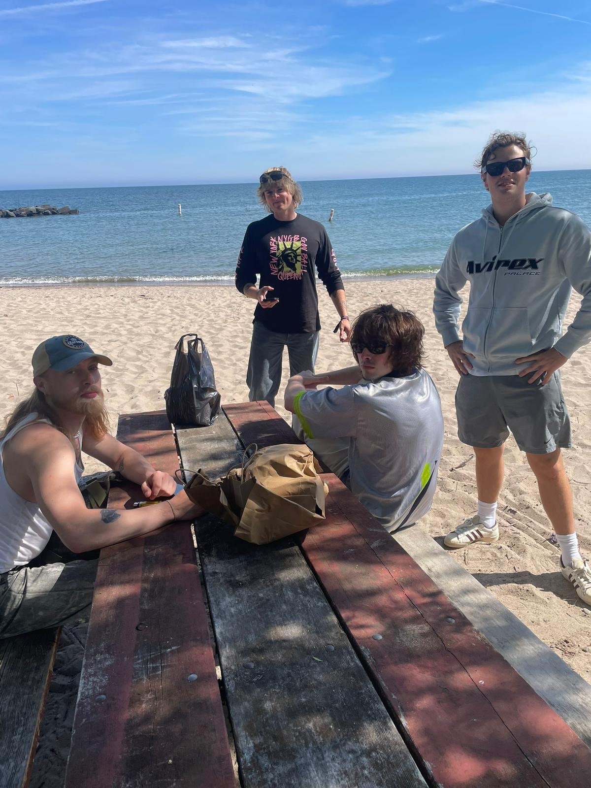 Members of Villanelle sit at a wooden table at the beach.