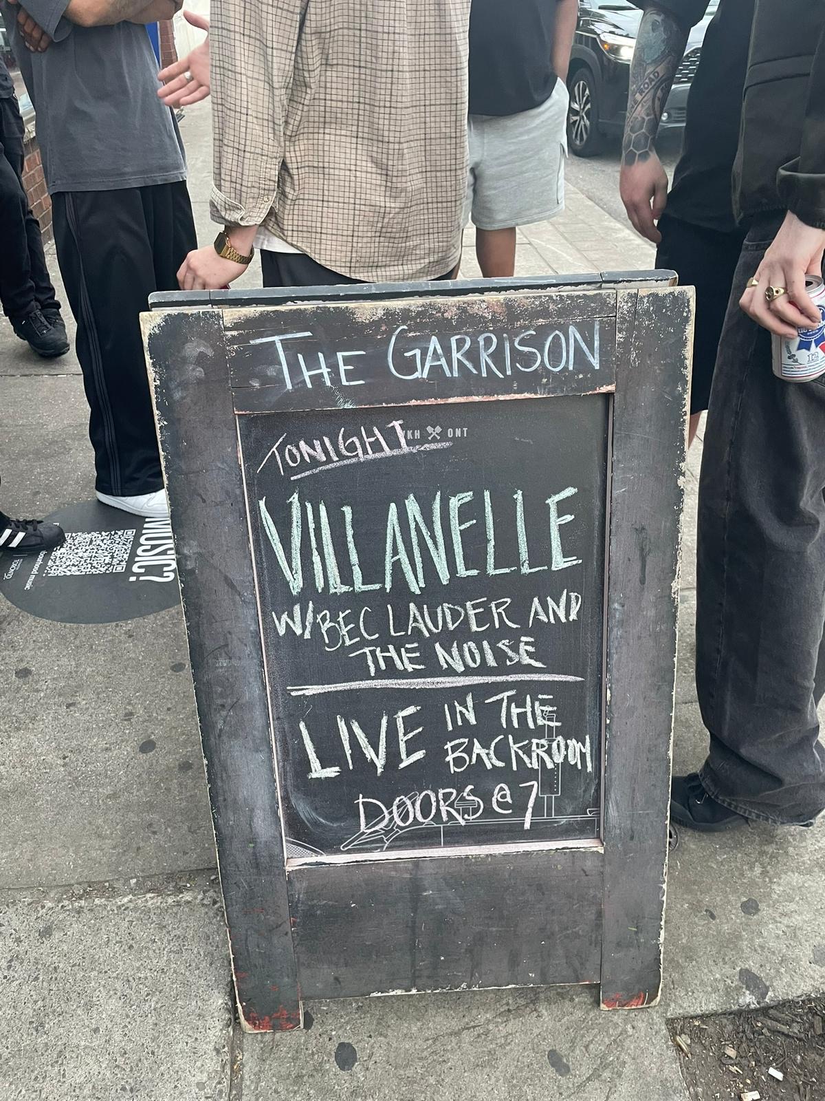 A chalk board sign from The Garrison which reads "Tonight Villanelle w/ Bec Lauder and The Noise Live in the backroom. Doors @ 7."
