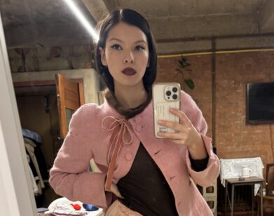 Sofia Testino taking a selfie in a pink jacket and white skirt