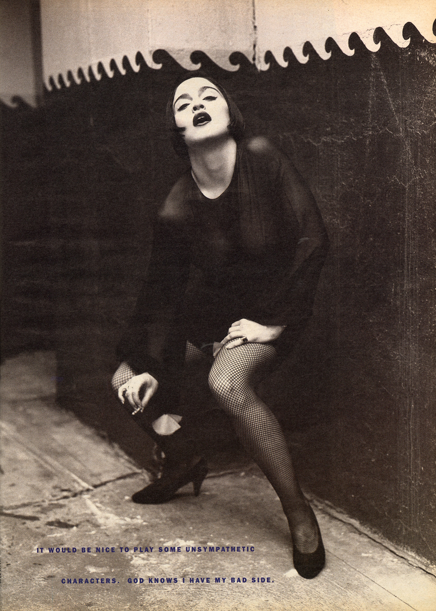 Madonna crouches wearing all black.