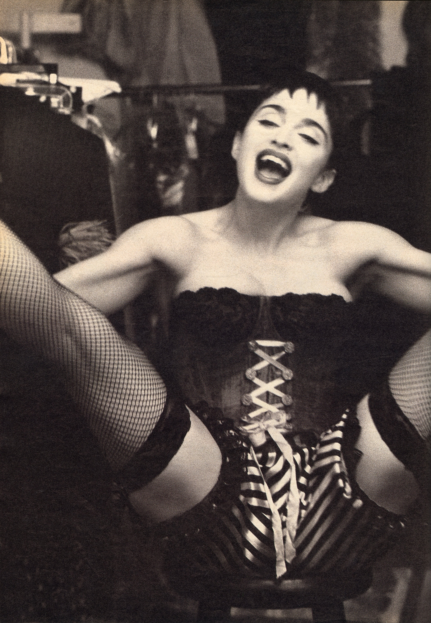 Madonna wearing a corset, spreading her legs and cheering.