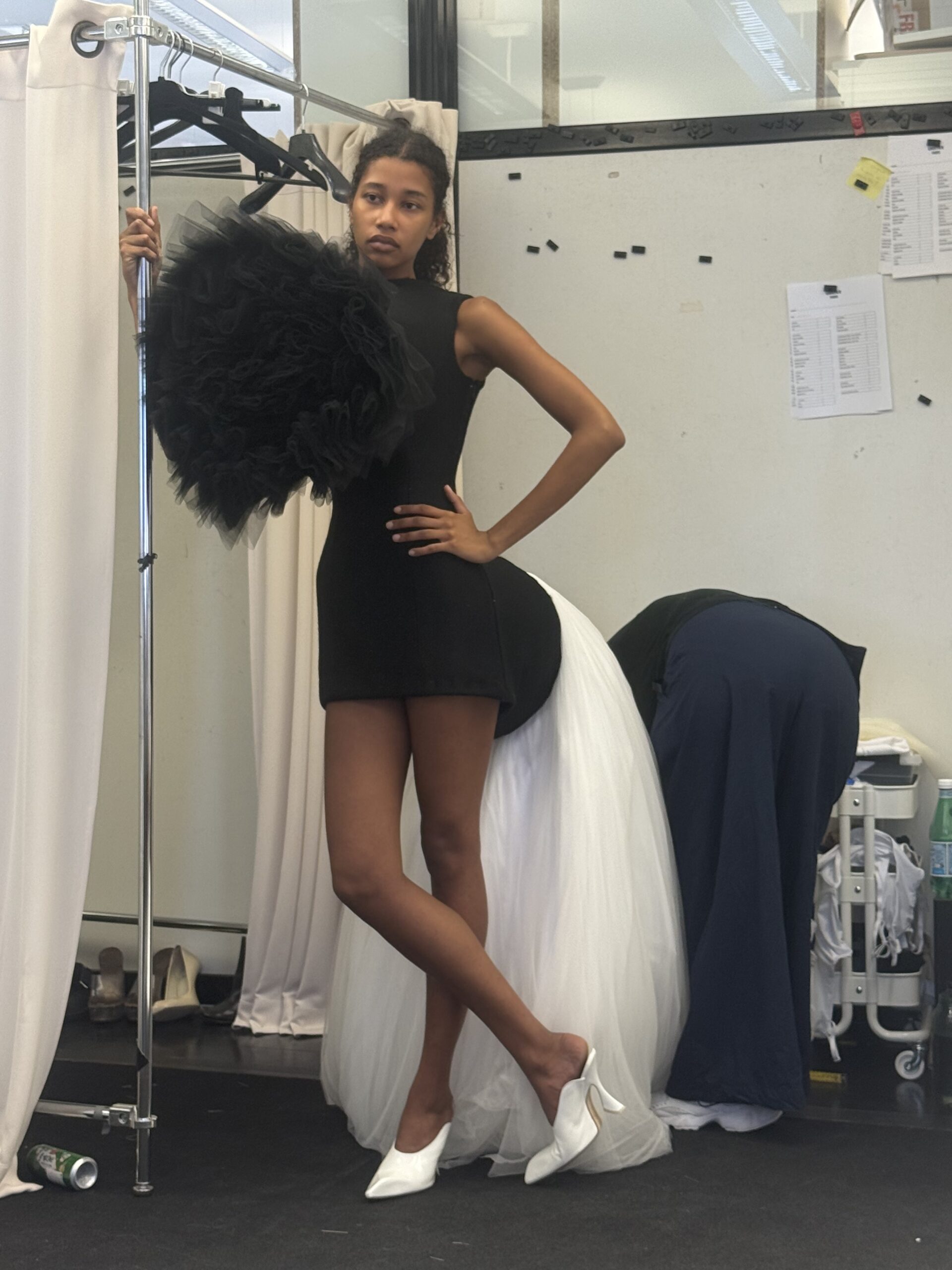 A model wearing a black and white puffy dress while backstage at Duran Lantink's show