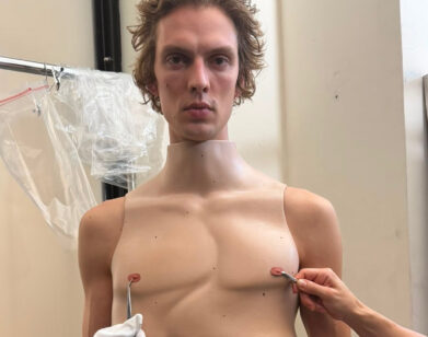 Model backstage at Duran Lantink's show wearing a twisted torso corset