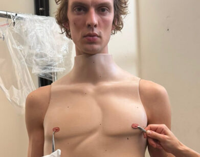 Model backstage at Duran Lantink's show wearing a twisted torso corset