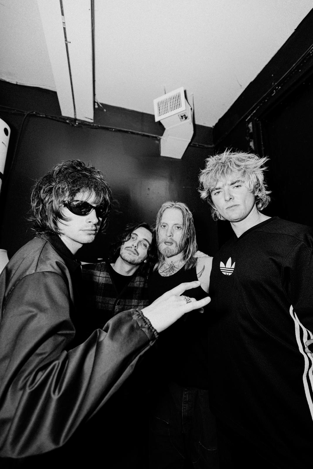 Gene Gallagher, Ben Taylor, and Jack Schiavo of Villanelle pose next to each other for a black and white photo