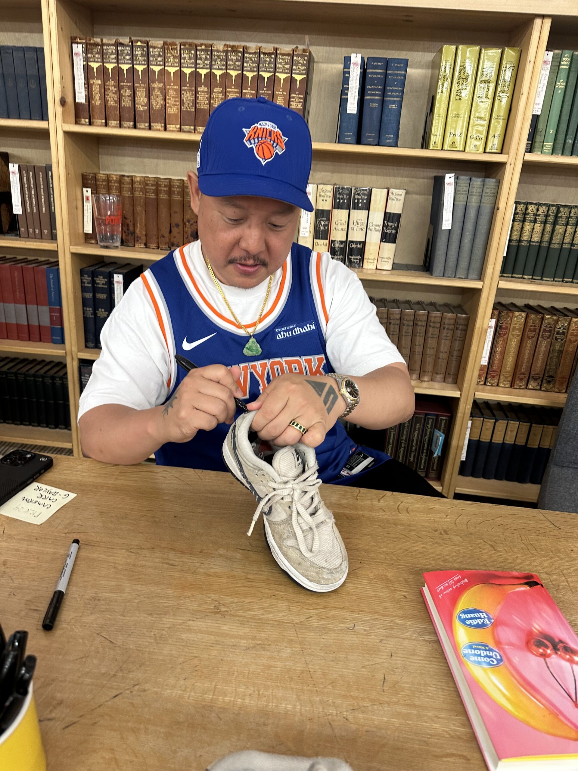 Eddie Huang signing a shoe.