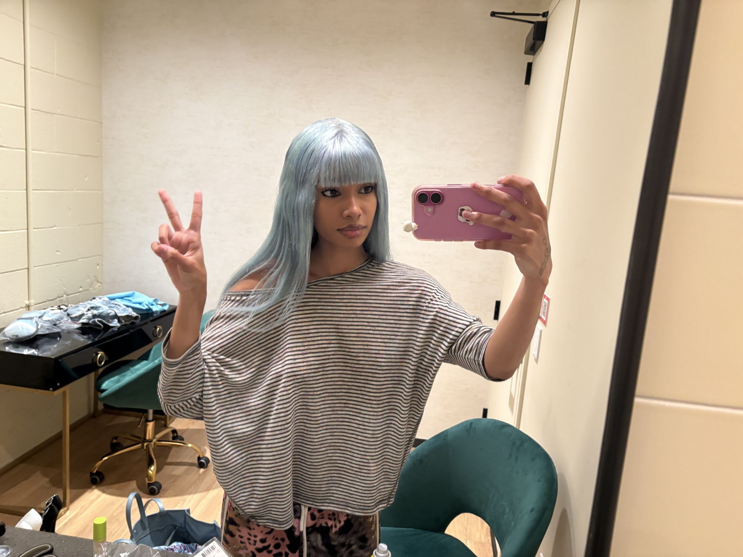 Cannelle holding a phone taking a mirror selfie