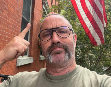 Alexis Bittar pointing to an American flag